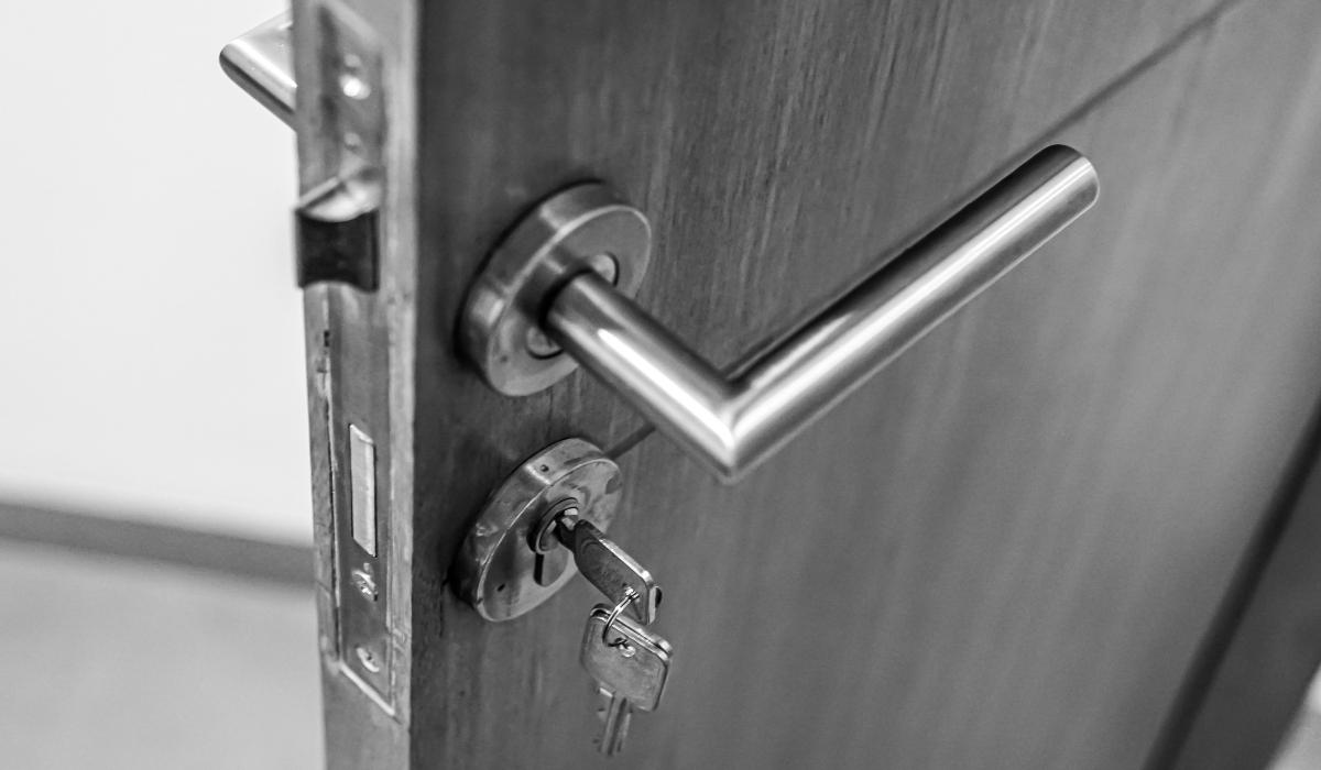 a door handle with a lock and a key in it on a wooden door