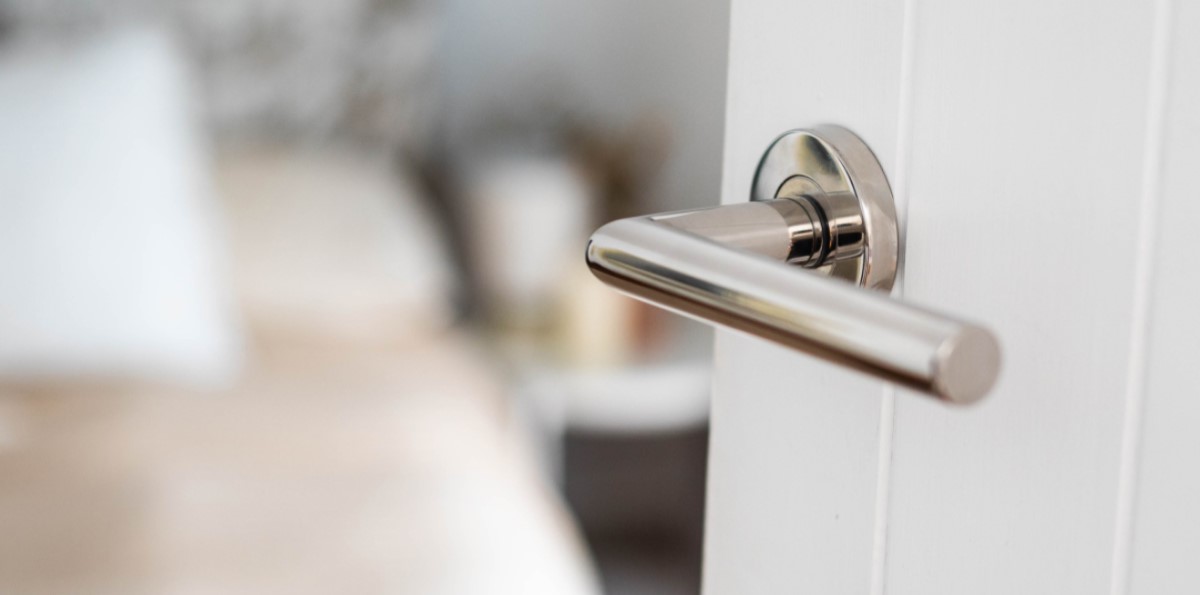 silver door handle on a white door